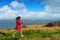 mature woman walking with sticks on the coast in northern France with ferries arriving in the port of Calais