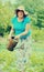 Mature woman watering potato plant