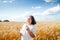 Mature woman in white on wheat field