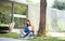 Mature woman working in home office outdoors in garden, resting.