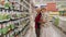 Mature women choose seeds on rack in garden supermarket