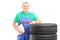 A mature worker posing on car tires with clipboard