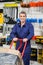 Mature Worker Pushing Trolley In Hardware Shop