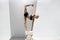 Mature Yoga Woman in Ionic Column Prop Supported Asana