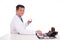 Matured Asian medical practitioner holding medicine seated behind desk