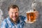 Matured smiling bearded man in shirt with beer mug