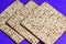 Matzah on blue background.Matza -Jewish traditional Passover unleavened bread. Pesach celebration symbol.