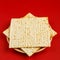 Matzah in the form of a star of David on a red background.