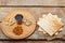 Matzah on a napkin and a round board with nuts and a glass of wine for kiddush on a wooden table.