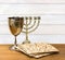 Matzo, menorah and wine in bowl for passover celebration on the wooden table  on background of white painted wooden planks