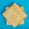 Matzo plates laid out in the form of a star of david on a blue background.