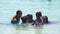 Mauritius, Blue Bay Beach, 18 January 2022: Indian happy family swimming in warm ocean with blue water. People of Indian