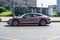 Mauve all-electric Porsche Taycan in motion. Speeding in city road concept