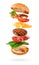 Maxi burger preparation with flying ingredients isolated on white background. Clipping path