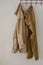 Maxi knitted sweater and a pair of trousers in warm natural colors hanging on the crutch on the wall, space for text