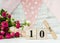May 10 date on a wooden calendar, roses, holiday flags and a garland on a white background