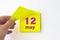 May 12nd. Day 12 of month, Calendar date. Hand rips off the yellow sheet of the calendar. Spring month, day of the year concept