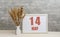 may 14. 14th day of month, calendar date. White vase with ikebana and photo frame with numbers on desktop, opposite