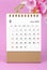 The May 2023 calendar desk and pink orchid on pink background
