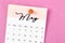 A May 2023 calendar and wooden push pin on pink colour background