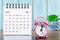 The May 2023 Monthly desk calendar for the organizer to plan 2023 year with pink alarm clock on wooden table