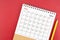 May 2024 desk calendar and pencil on red background