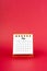 May 2024 white mini desk calendar on red background