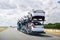 May 25, 2018 Bakersfield / CA / USA - Car transporter carries Tesla Model 3 new vehicles along the highway, back view of the