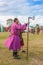 May 9 2014 Brisbane Australia - Man dressed in purple ornate robe holding late Scandinavian Viking cross axe at Living History re-