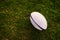 May the games begin. a rugby ball on an empty rugby field during the early hours of the morning.