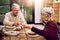 May we have many more years together. an elderly couple toasting with wine glasses while they enjoy a meal at home.