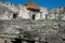 Maya ruins with straw roof behind blurred wall, Tulum, Mexico