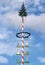 Maypole with craft guild marks, blue and white sky