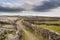 Maze of traditional dry stone walls and green fields. Landscape of Inishmore Aran islands, county Galway, Ireland. Dramatic sky in