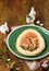 Mazurek, Polish Easter sweet made from shortcrust pastry in the shape of an egg with Easter decoration on a green plate on a