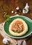 Mazurek, Polish Easter sweet made from shortcrust pastry in the shape of an egg with Easter decoration on a green plate on a