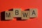 MBWA Acronym in 3D wooden alphabet letters isolated on red background