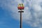 Mc Donald`s and Mc Drive signboard pole against blue sky with clouds