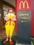McDonald character pretending to pray and set beside the drive thru sign