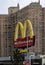 McDonald\\\'s fast food restaurant sign with golden arches in front of a tall high rise building in Brooklyn, New York City.