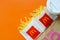 McDonald`s French fries in small paperbag and coffee cup on bright orange background