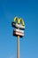 McDonald's restauraunt sign with blue sky in the background. McDonald's sell fast food such as hamburgers, french fries