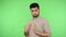 This is me! Arrogant brunette man pointing himself, looking haughty egoistic at camera. green background, chroma key