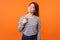 This is me! Portrait of proud young woman with brown hair in long sleeve striped shirt. indoor studio shot  on orange