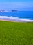 Meadow and beach in the city of Zarautz, with the island San AntÃ³n Raton de Getaria