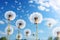 Meadow, blue sky and group of dandelions blowing in the wind