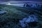 Meadow with huge stones on top of mountain range at night