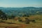 Meadows and trees in a green valley with hilly landscape