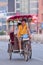 Meager man on a rickshaw with passenger, Beijing, China