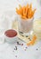 Meal deal snack french fries potato chips in glass with tomato ketchup and pepper on yellow restaurant paper